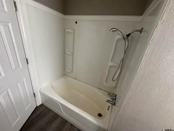 a white bath tub sitting next to a white sink and vanity