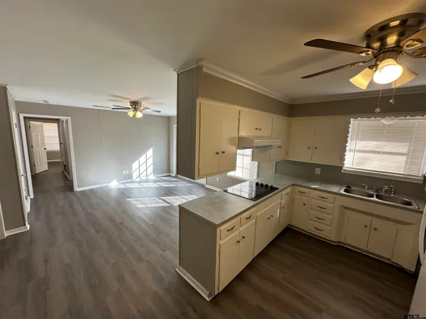 a kitchen with a stove and wooden floor