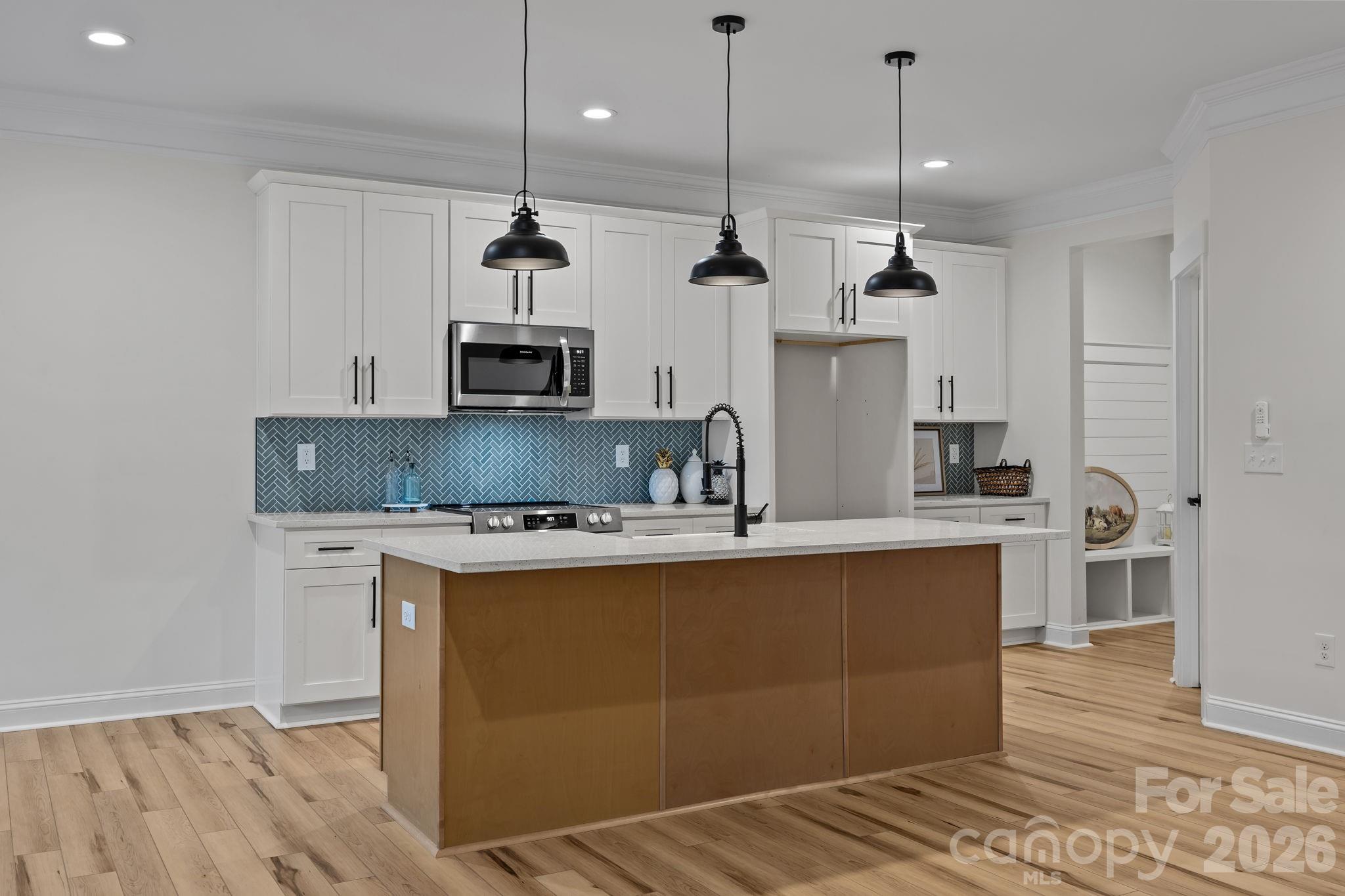 1030 Gibson Road Salisbury, NC 28147 - Photo 16 of 47 a kitchen with stainless steel appliances granite countertop a sink a stove a refrigerator and island with wooden floor