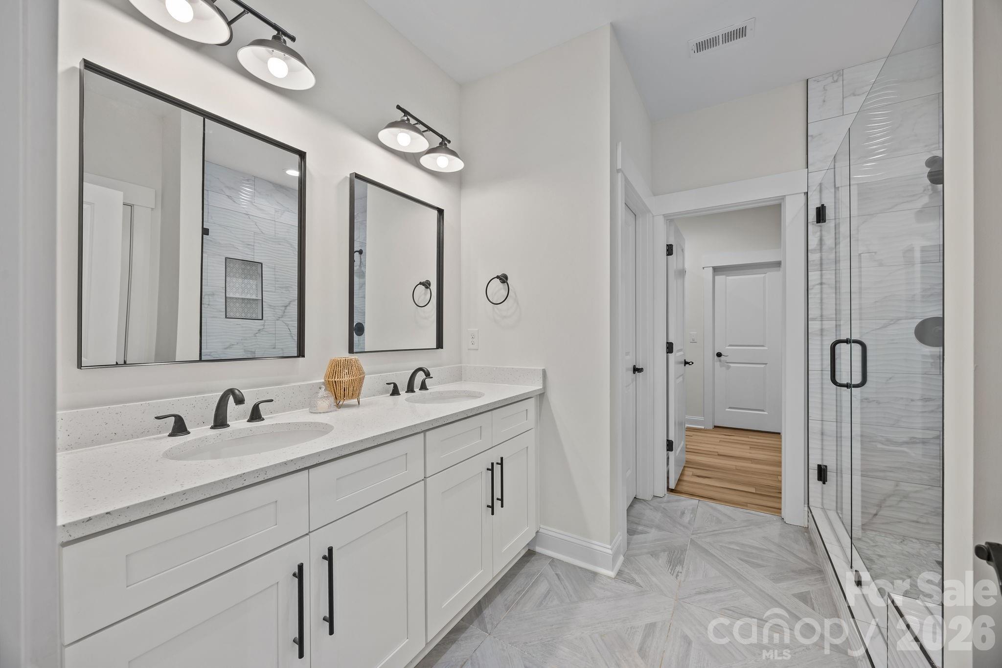 1030 Gibson Road Salisbury, NC 28147 - Photo 27 of 47 a bathroom with a double vanity sink and mirror with shower