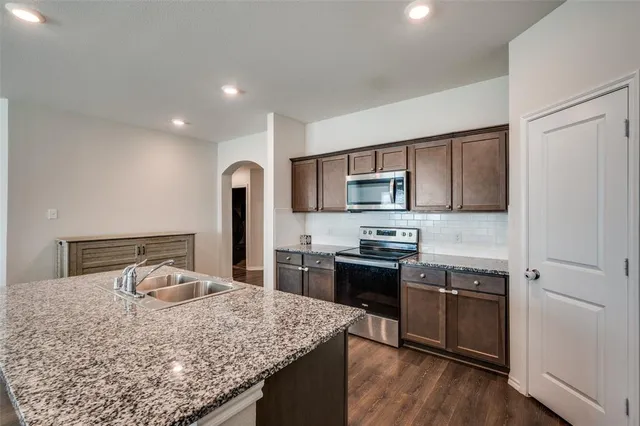 a kitchen with stainless steel appliances granite countertop counter space a sink and cabinets