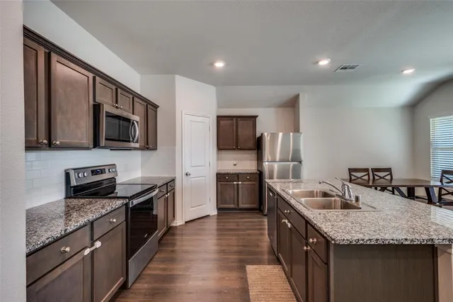 a kitchen with granite countertop stainless steel appliances and wooden cabinets