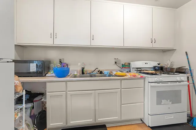 a kitchen with white cabinets and white appliances