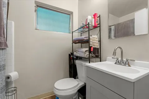 a bathroom with a sink vanity mirror and toilet