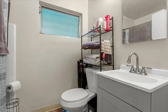 a bathroom with a sink vanity mirror and toilet