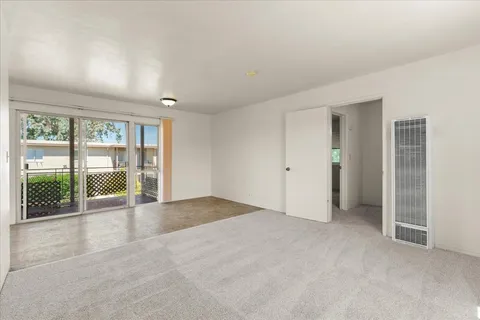 an empty room with sliding glass door and outer view