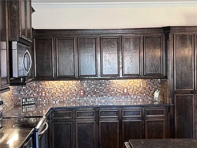 a kitchen with stainless steel appliances granite countertop a sink and wooden cabinets