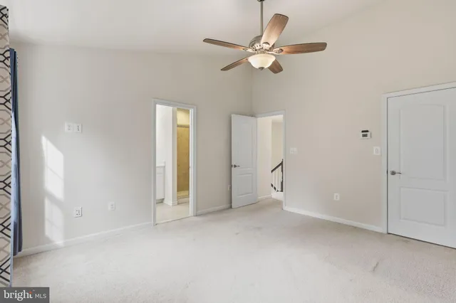 an empty room with fan and entrance