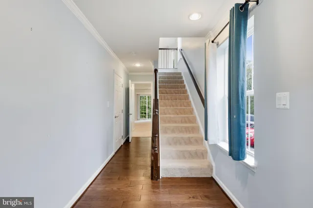 a view of a hallway with wooden floor and entryway