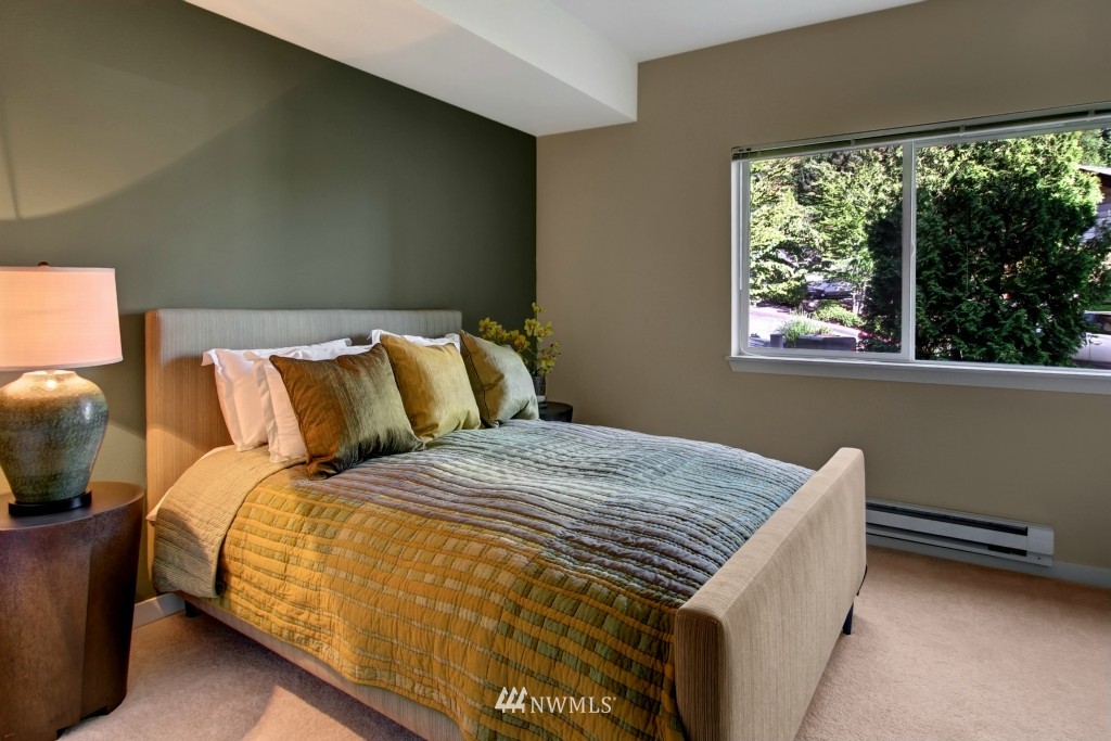 3921 243rd Place Southeast, Unit J202 Bothell, WA 98021 - Photo 8 of 16 a bed sitting in a bedroom next to a window