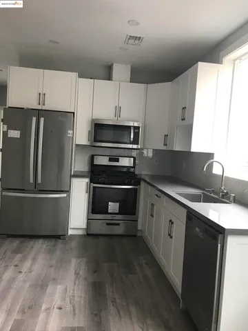a kitchen with a refrigerator and a stove top oven