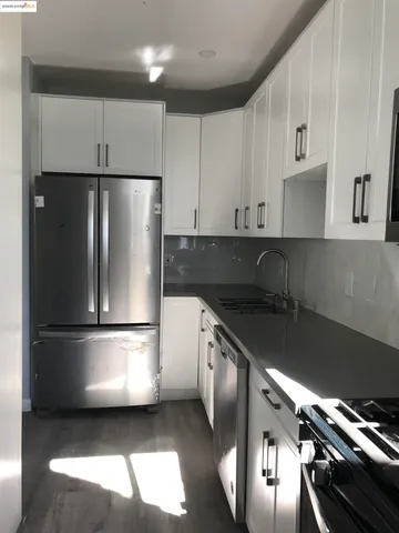 a kitchen with white cabinets and appliances