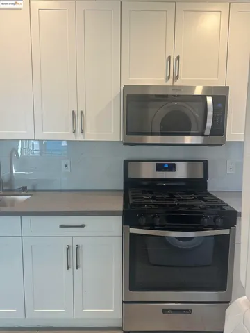 a kitchen with stainless steel appliances granite countertop a sink and a stove
