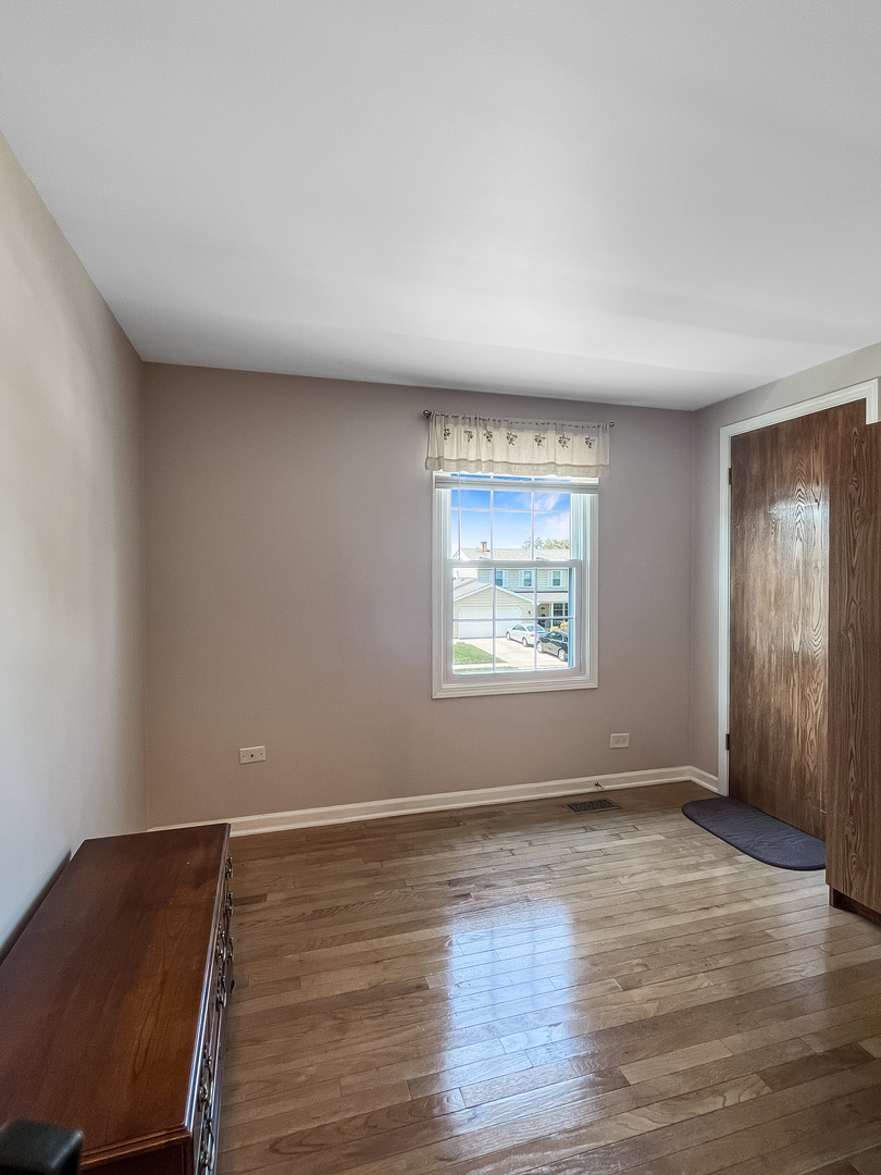 985 Greenridge Road Buffalo Grove, IL 60089 - Photo 13 of 20 an empty room with wooden floor and windows