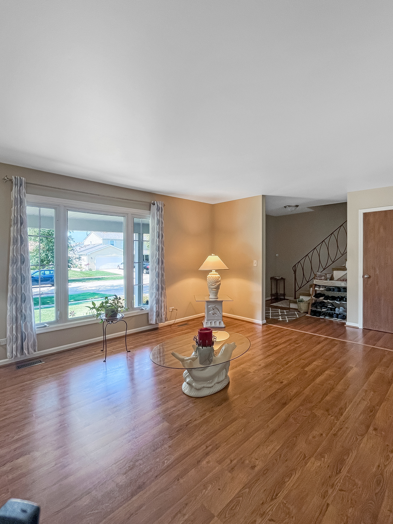 985 Greenridge Road Buffalo Grove, IL 60089 - Photo 3 of 20 a living room with furniture a fireplace and wooden floor