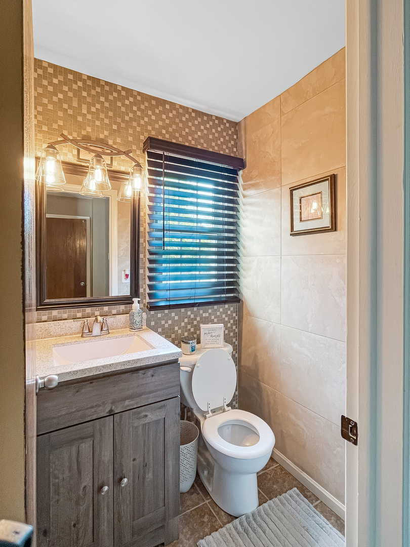 985 Greenridge Road Buffalo Grove, IL 60089 - Photo 7 of 20 a bathroom with a granite countertop toilet sink and mirror