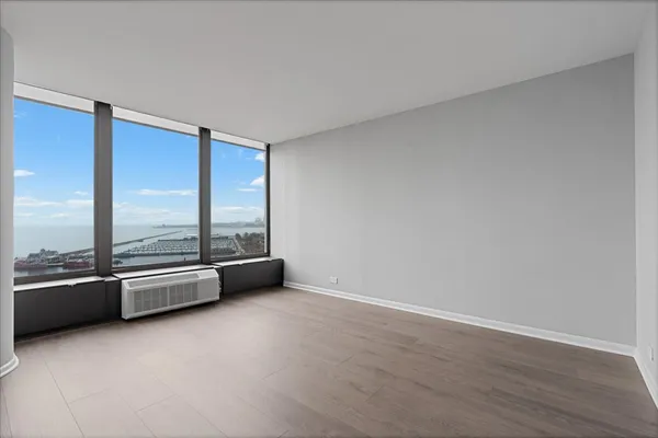 an empty room with wooden floor and glass door