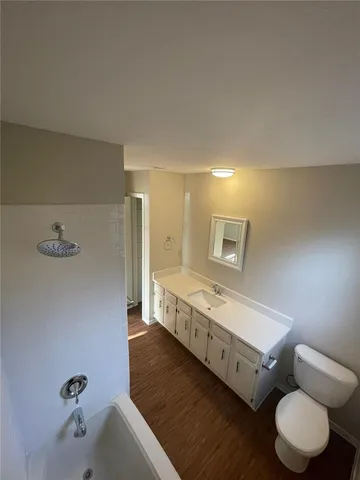 a bathroom with a double vanity sink and mirror with bathtub