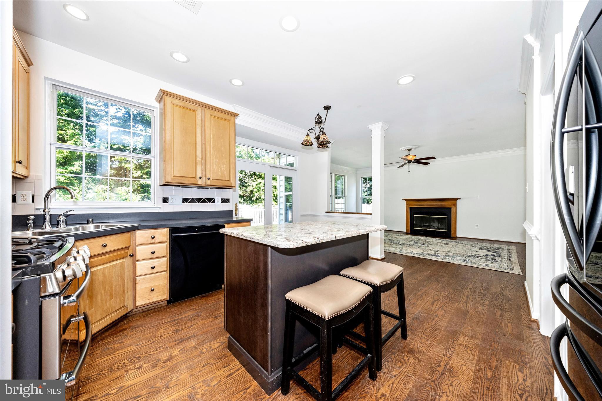 803 Apache Court Frederick, MD 21701 - Photo 8 of 46 a kitchen with stainless steel appliances granite countertop a sink a stove a refrigerator and a dining table with wooden floor