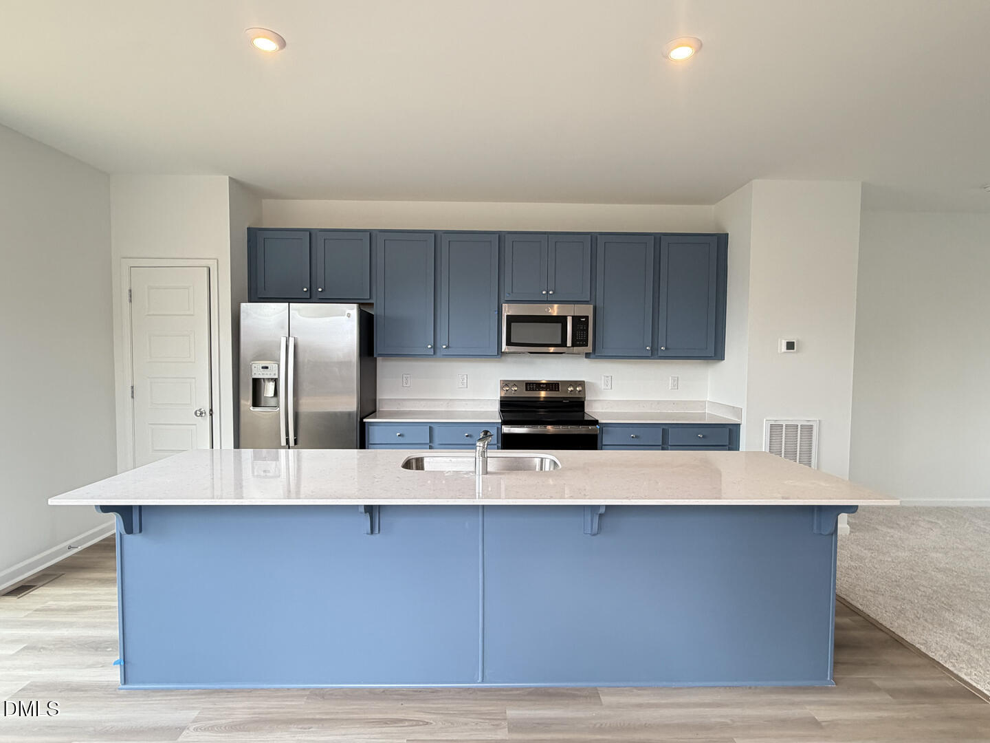 3328 Bomore Road Raleigh, NC 27610 - Photo 13 of 47 a large kitchen with stainless steel appliances a refrigerator a stove a sink a microwave and wooden cabinets