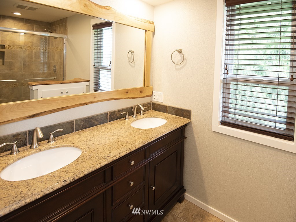 21922 Southeast 255th Place Maple Valley, WA 98038 - Photo 15 of 40 a bathroom with a granite countertop sink and a mirror