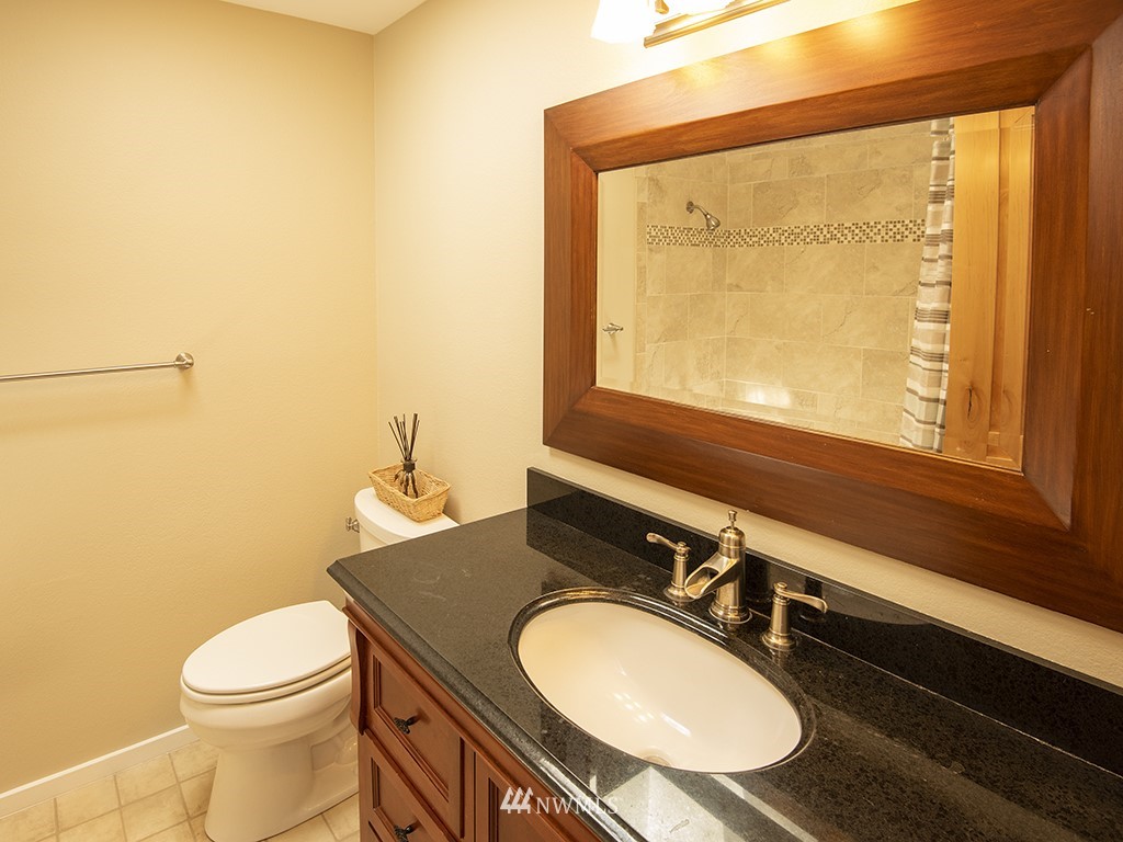21922 Southeast 255th Place Maple Valley, WA 98038 - Photo 20 of 40 a bathroom with a granite countertop sink vanity mirror and toilet
