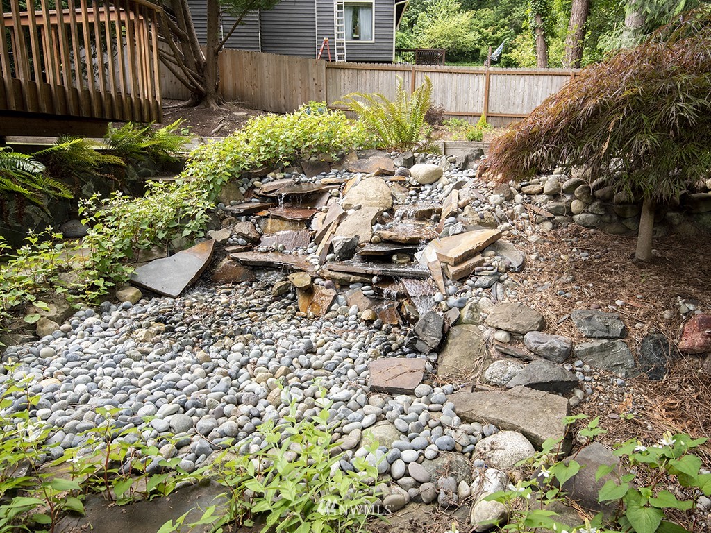 21922 Southeast 255th Place Maple Valley, WA 98038 - Photo 31 of 40 a view of a backyard with plants and wooden fence