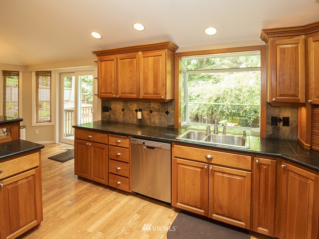 21922 Southeast 255th Place Maple Valley, WA 98038 - Photo 6 of 40 a large kitchen with granite countertop a large window and a sink
