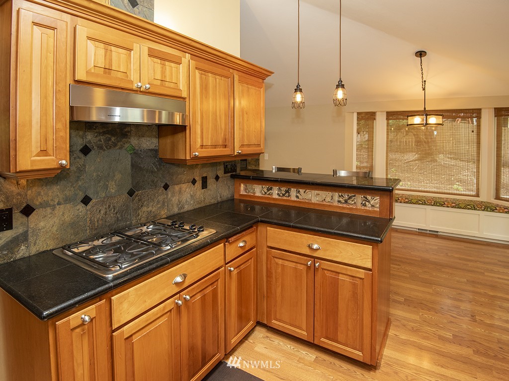 21922 Southeast 255th Place Maple Valley, WA 98038 - Photo 7 of 40 a kitchen with stainless steel appliances granite countertop a stove a sink and a microwave