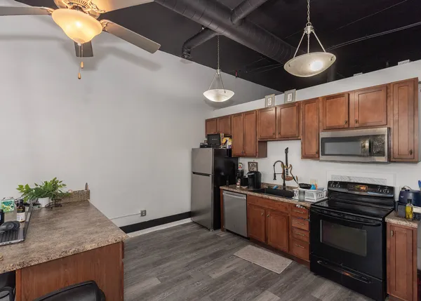 a room with water heater and wooden cabinets