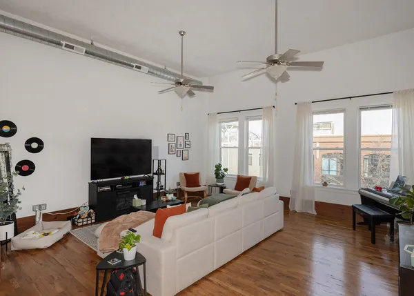 a living room with furniture large window and wooden floor