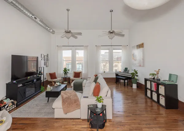 a view of a livingroom with wooden floor and stairs