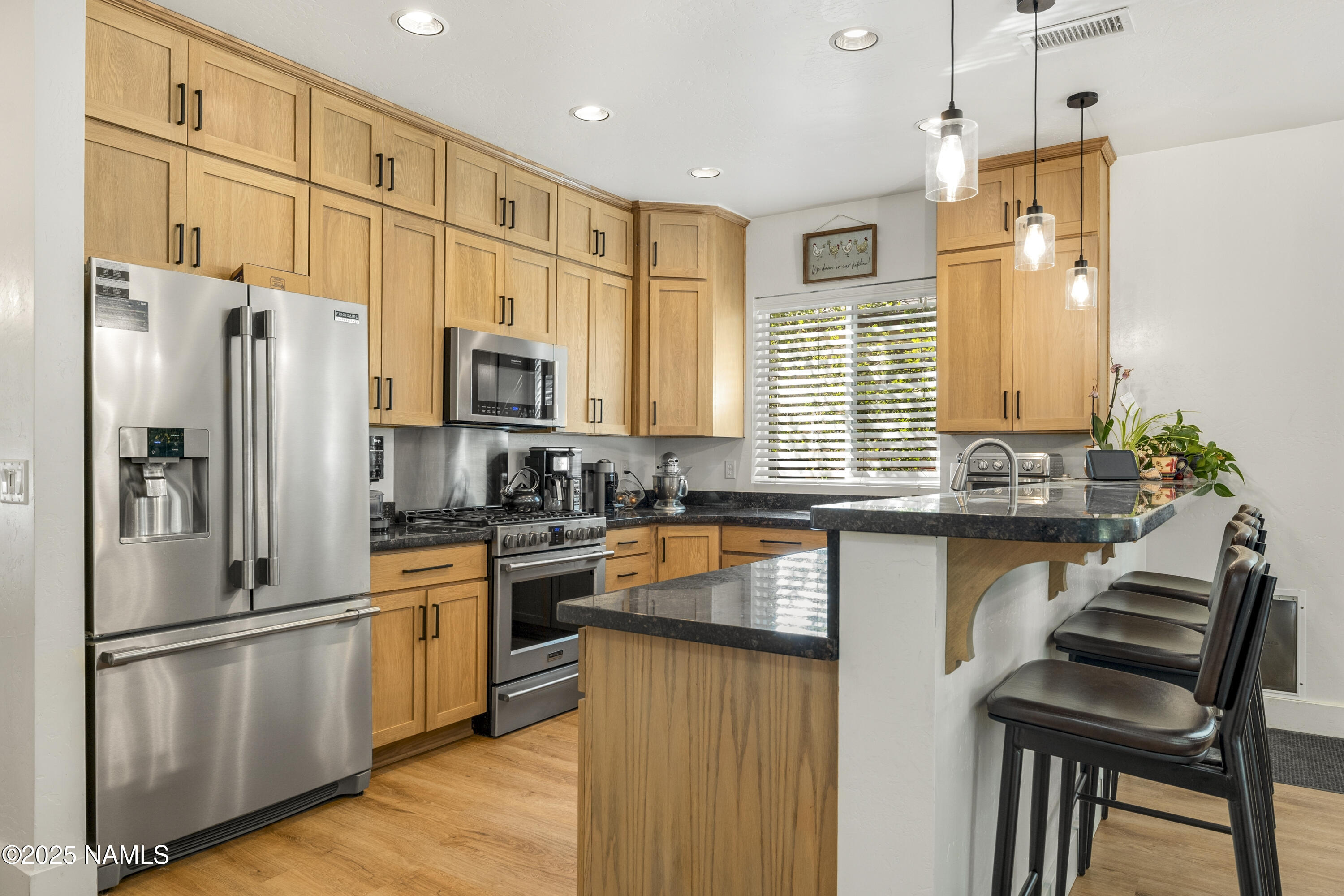 5053 South Topaz Road Flagstaff, AZ 86005 - Photo 8 of 25 a kitchen with granite countertop stainless steel appliances a refrigerator a stove a sink cabinets and a dining table