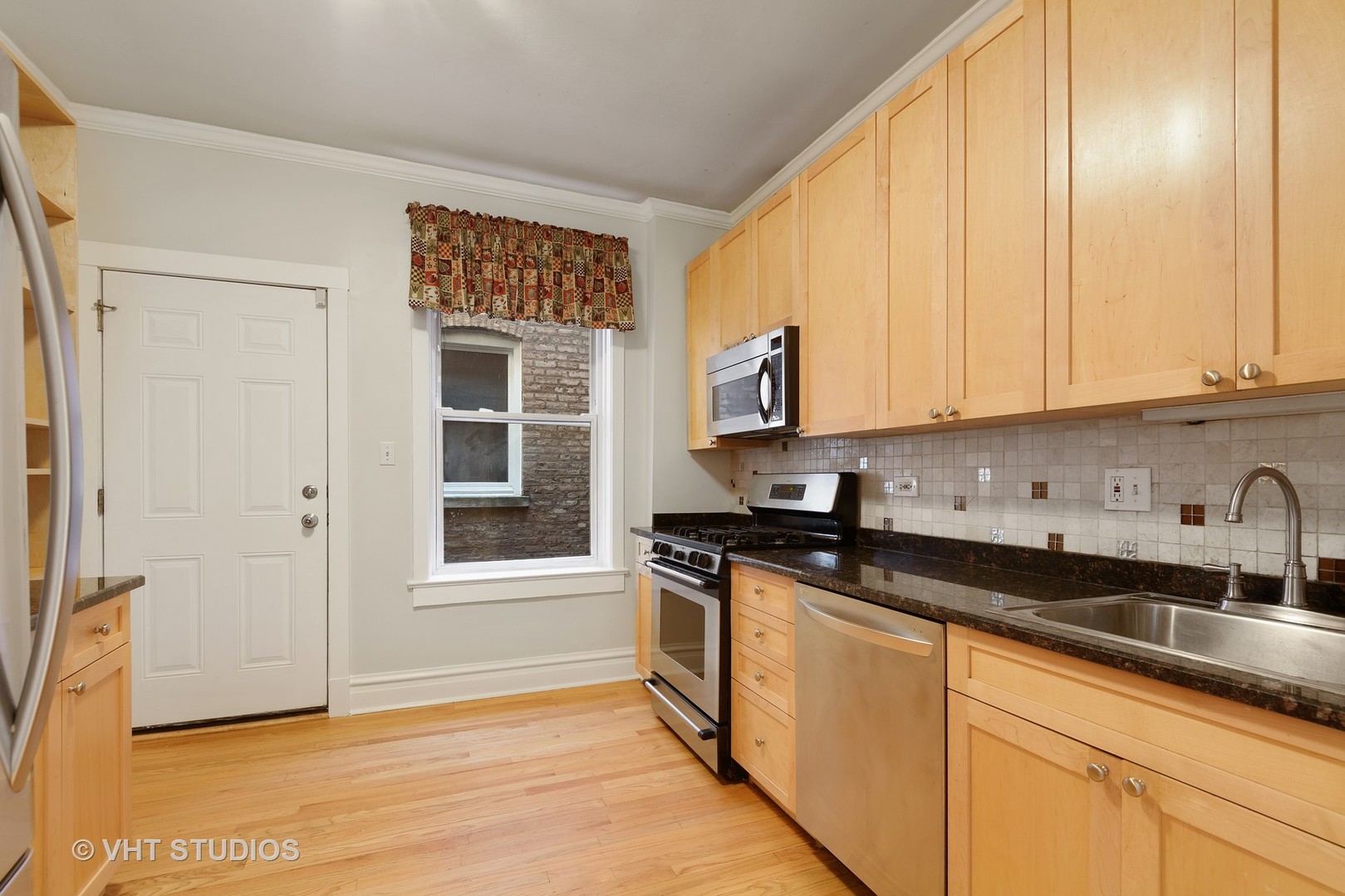 834 West Lakeside Place, Unit 2N Chicago, IL 60640 - Photo 4 of 13 a kitchen with granite countertop a stove a sink and white cabinets