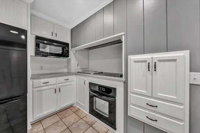 a kitchen with white cabinets and stainless steel appliances