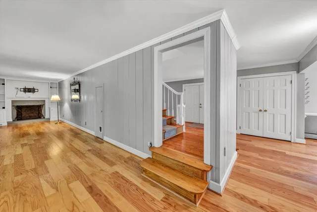 a view of empty room with wooden floor and fireplace