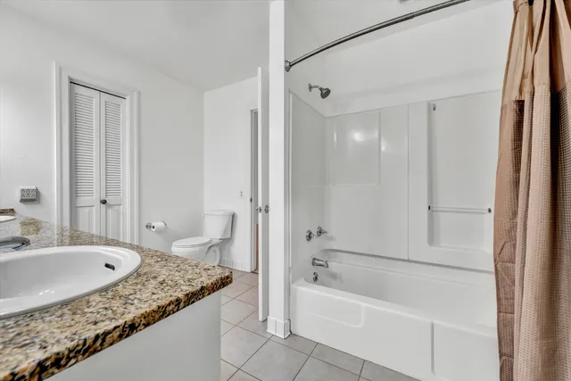 a bathroom with a granite countertop tub sink and mirror