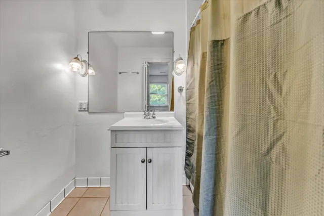 a bathroom with a sink a mirror and shower