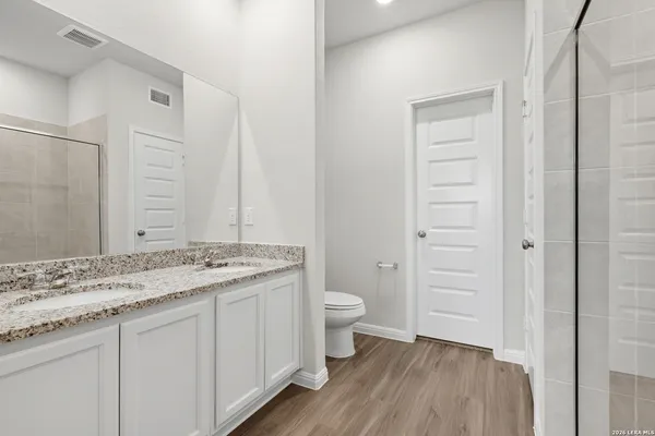 a bathroom with a granite countertop sink toilet and shower