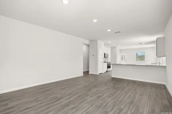 a view of an empty room with wooden floor