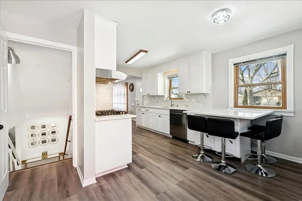 a kitchen with a table chairs refrigerator and window