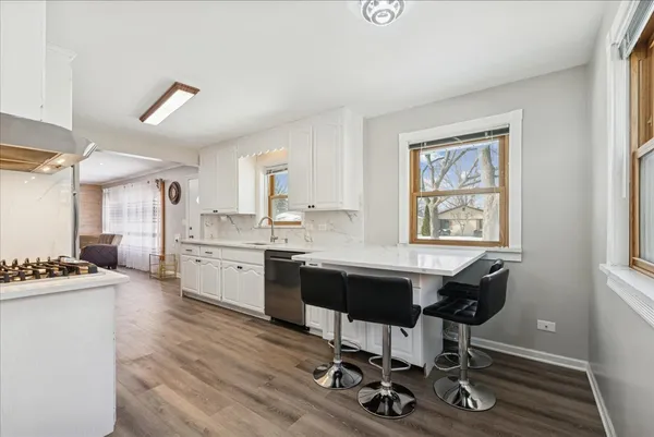 a view of a kitchen with workspace and wooden floor