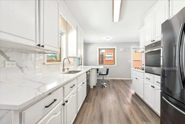 a kitchen with stainless steel appliances a sink stove and refrigerator