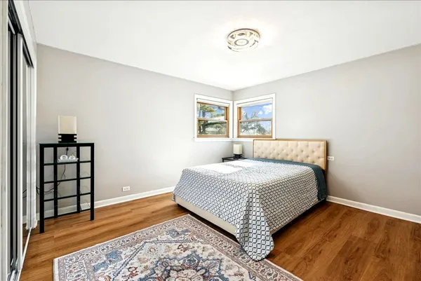 a bedroom with a bed and wooden floor