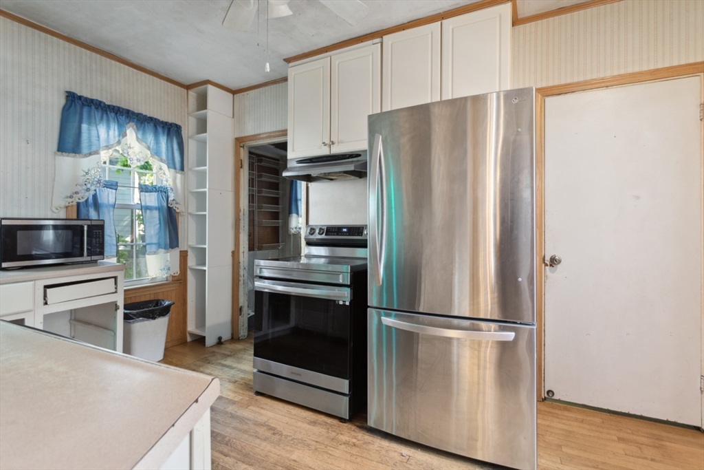 40 Village Street Reading, MA 01867 - Photo 13 of 36 a kitchen with stainless steel appliances a refrigerator and a stove top oven