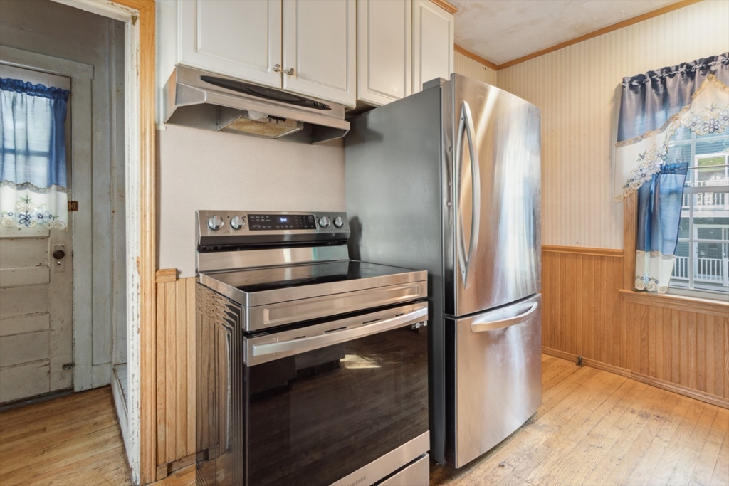 40 Village Street Reading, MA 01867 - Photo 15 of 36 a kitchen with a refrigerator stove and cabinets