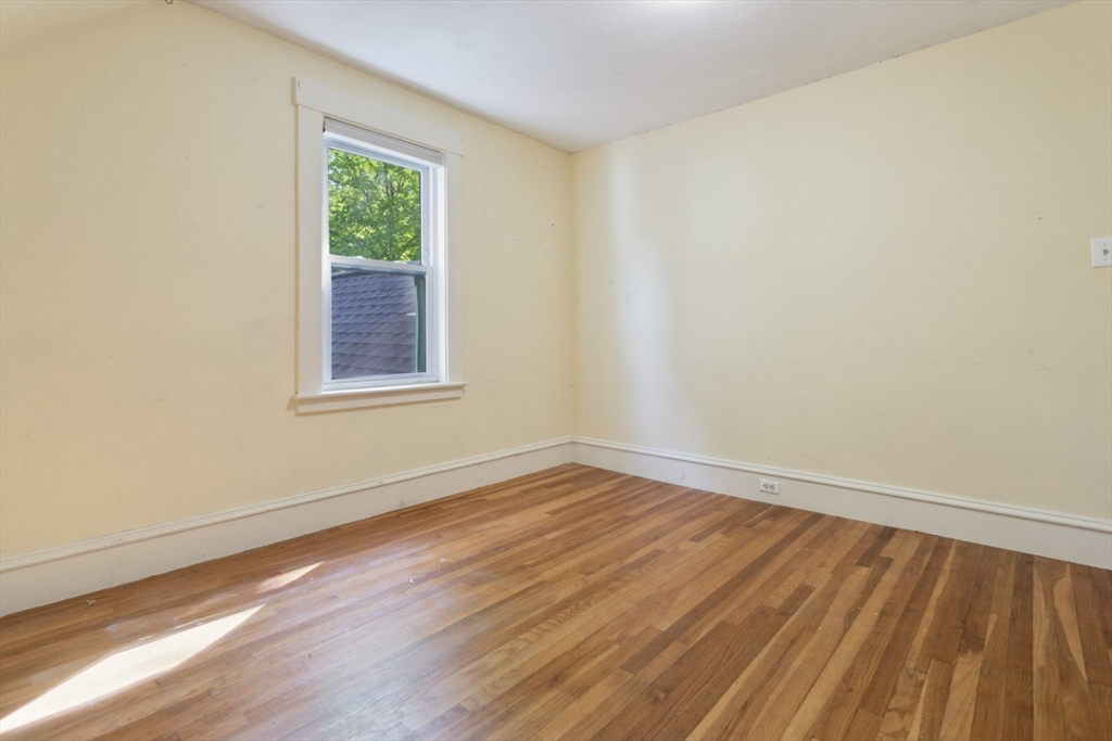 40 Village Street Reading, MA 01867 - Photo 22 of 36 a view of an empty room with wooden floor and a window