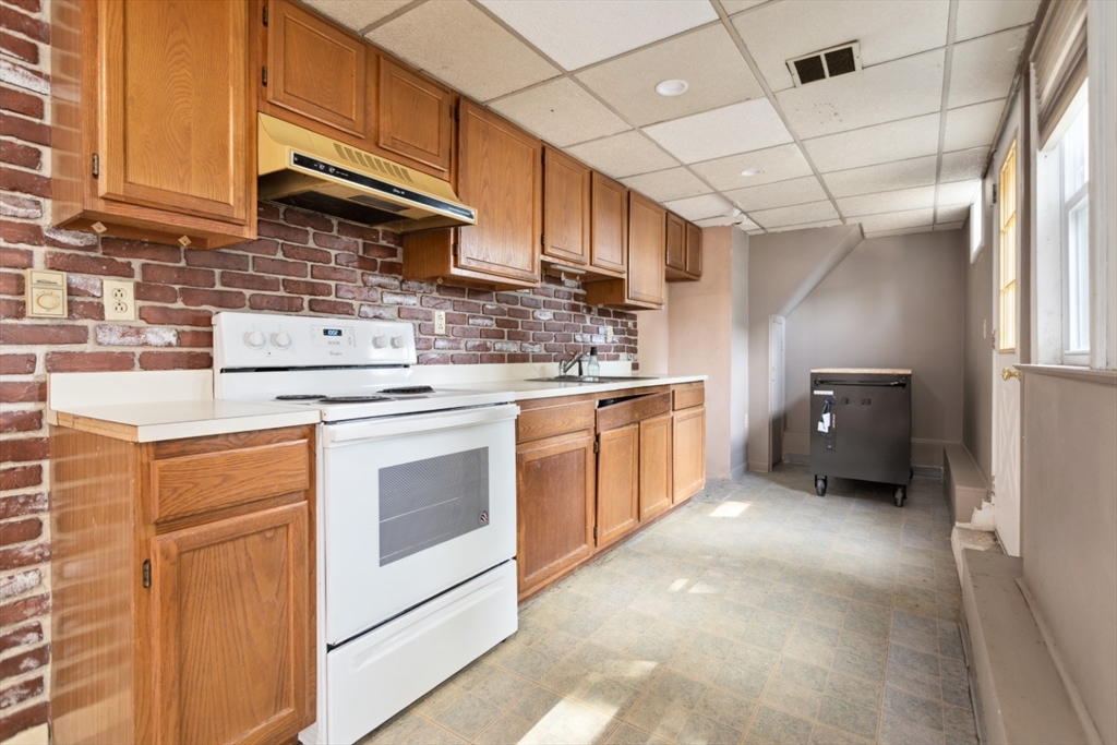 40 Village Street Reading, MA 01867 - Photo 30 of 36 a kitchen with stainless steel appliances granite countertop a sink a stove and a refrigerator