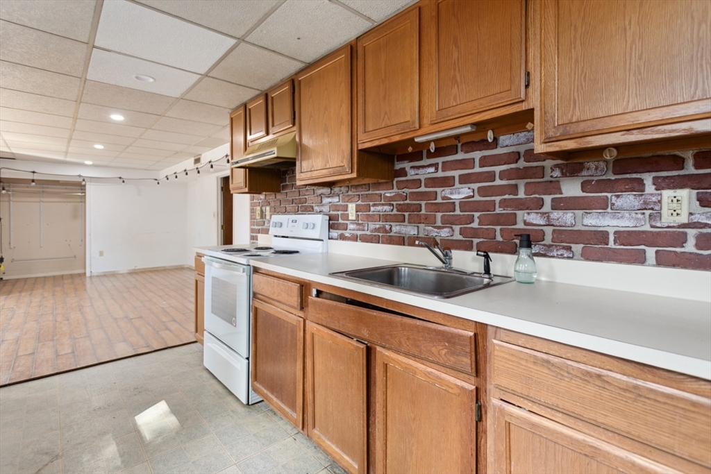 40 Village Street Reading, MA 01867 - Photo 31 of 36 a kitchen with stainless steel appliances granite countertop a sink a stove and cabinets