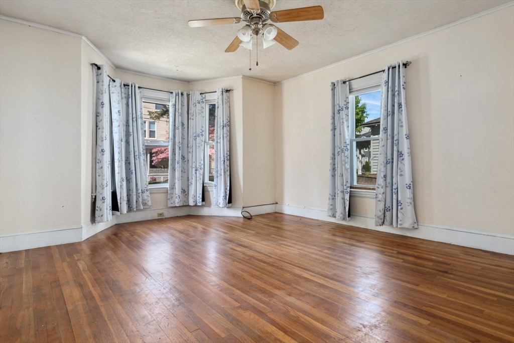 40 Village Street Reading, MA 01867 - Photo 5 of 36 an empty room with wooden floor chandelier and windows